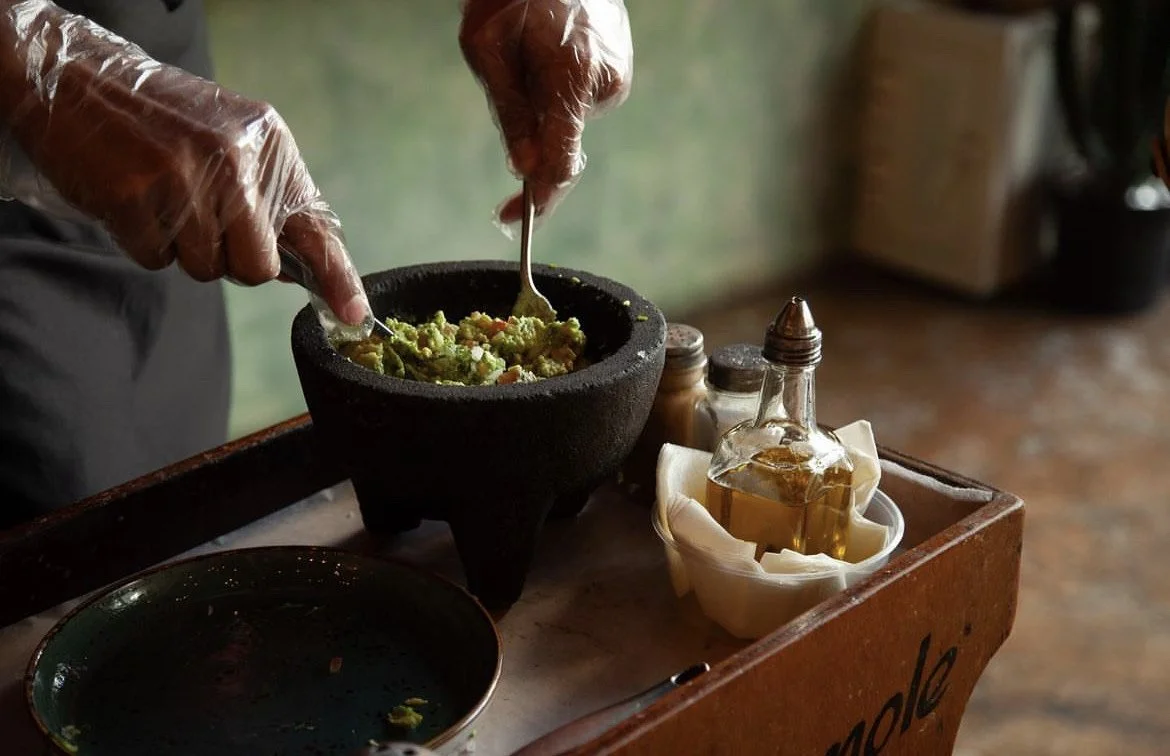 Guacamole being prepared in a molcajete